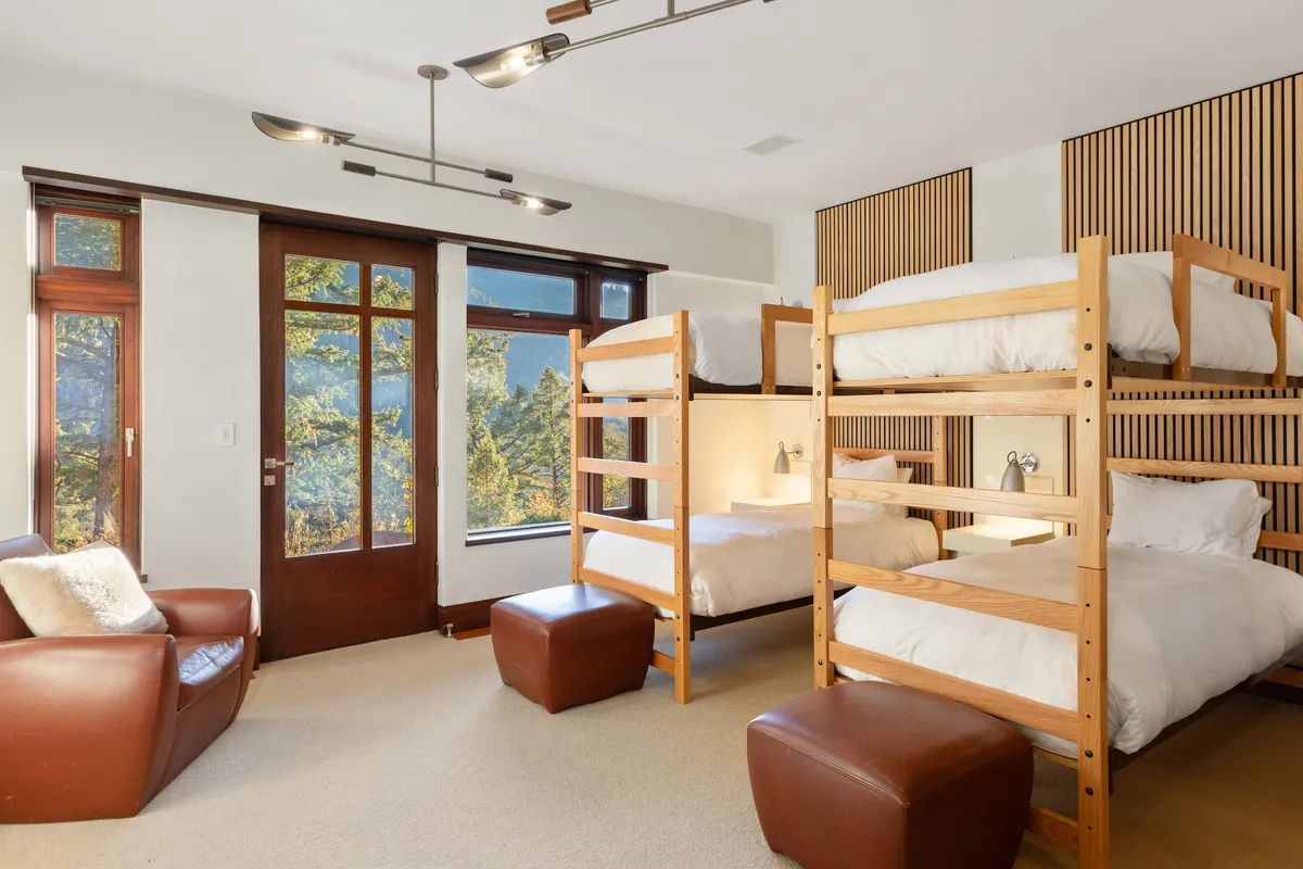 A playful bunk room with large windows, bunk beds, and comfortable seating. The ambience is relaxed and family-friendly, offering a perfect retreat for children or group stays while still soaking in the tranquil views.